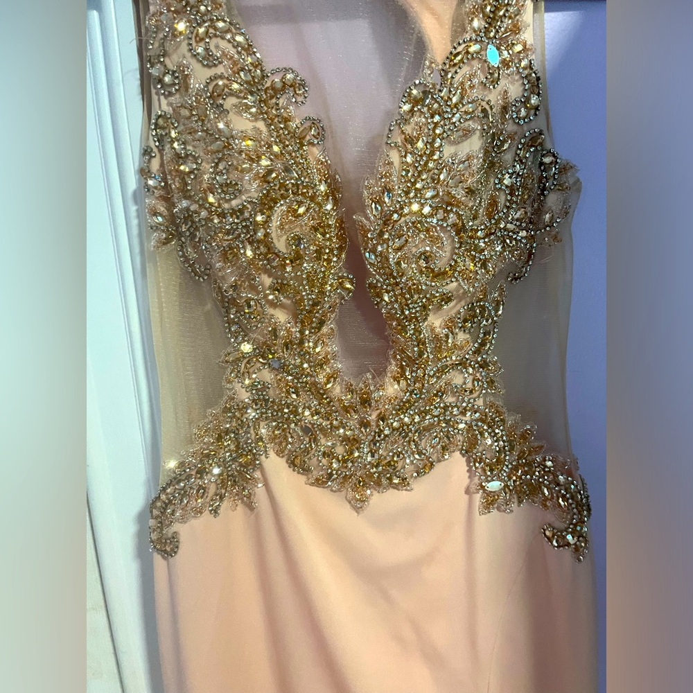 Peach colored hand placed rhinestone prom dress with a slit and train